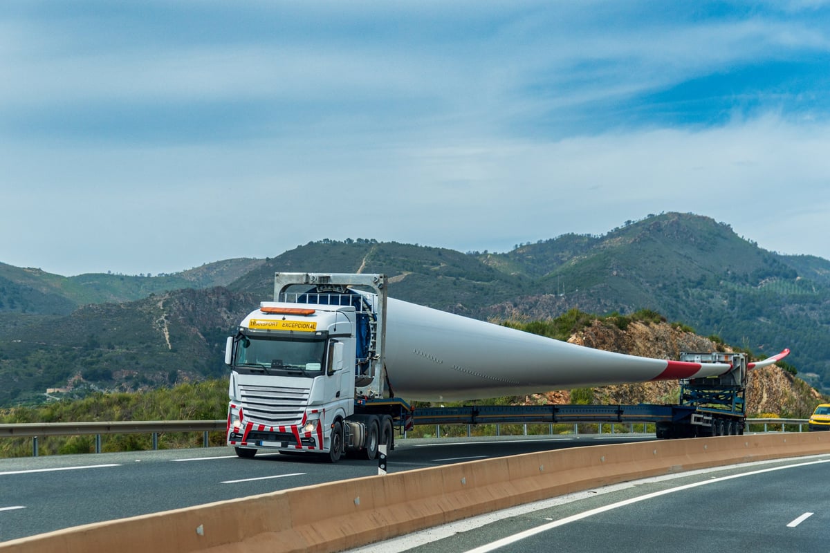 Truck carrying a wind turbine blade on a specialized trailer